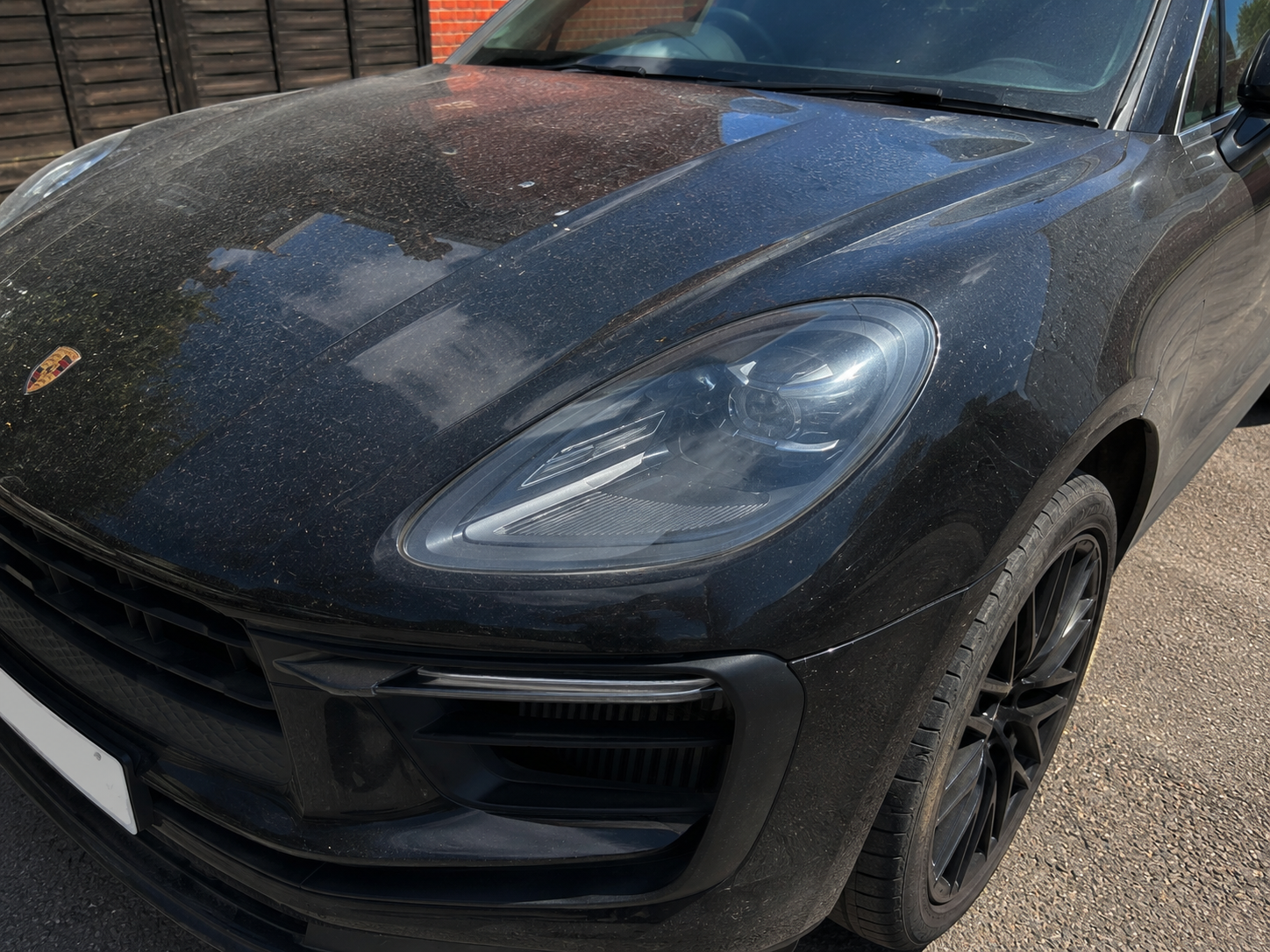 Dark BMW before detailing — covered in road grime, mud, and dull paint